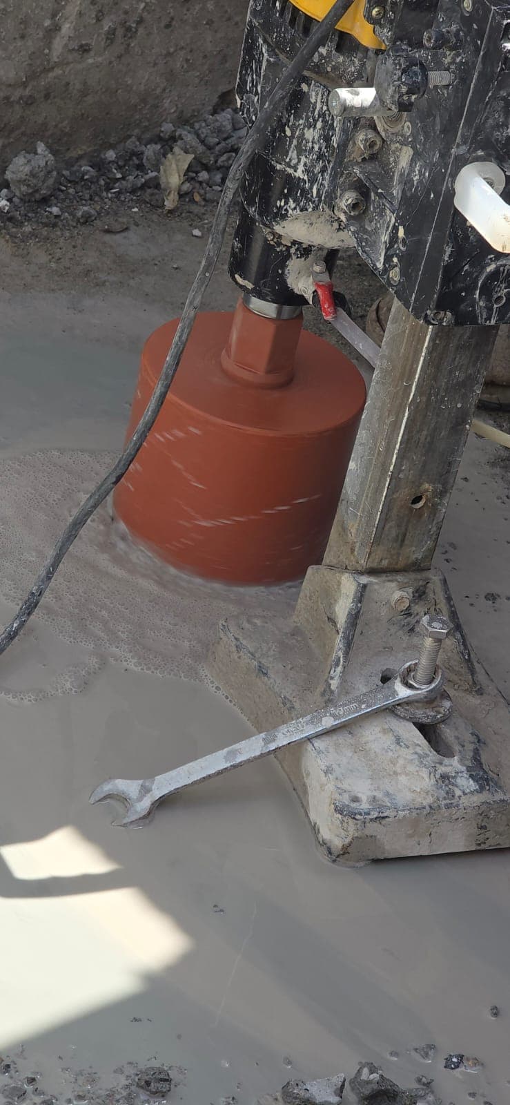 Diamond core cutting in Dubai - core drill bit cutting into concrete slab UAE construction project